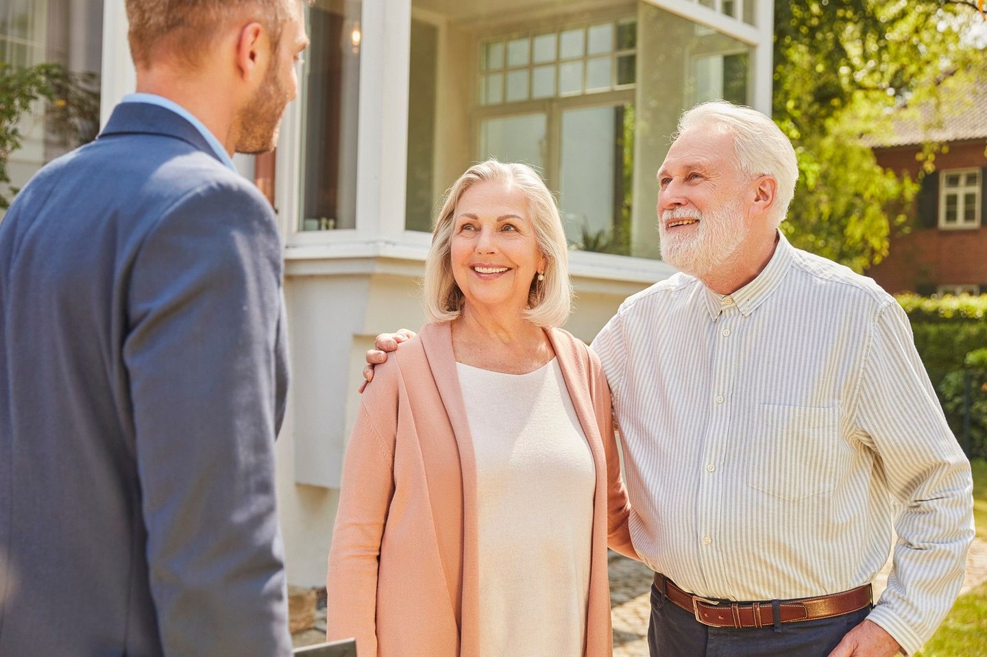 Ein Paar lässt sich vor ihrem Haus zu dem Thema Mieteigentum beraten.