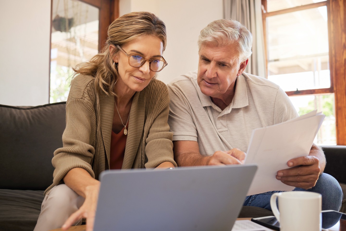 Älteres Pärchen recherchiert auf dem Laptop Details zur Immobilienverrentung