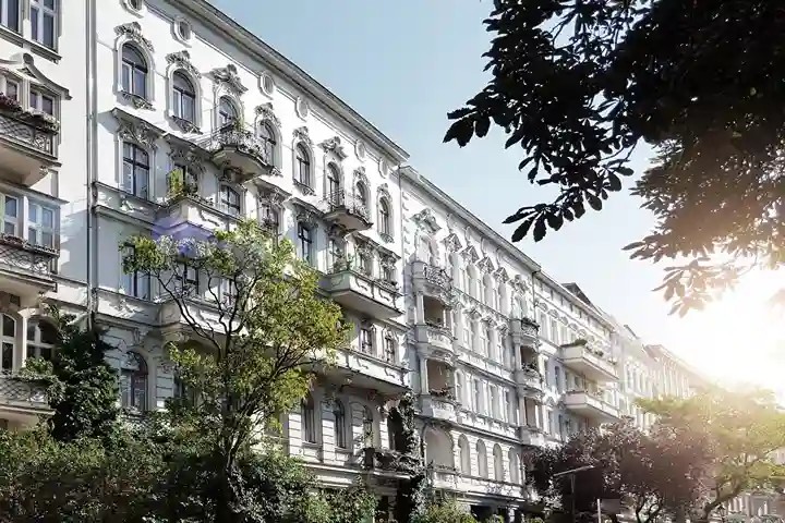 Ein Wohnblock von weißen Wohnungen und Bäumen.