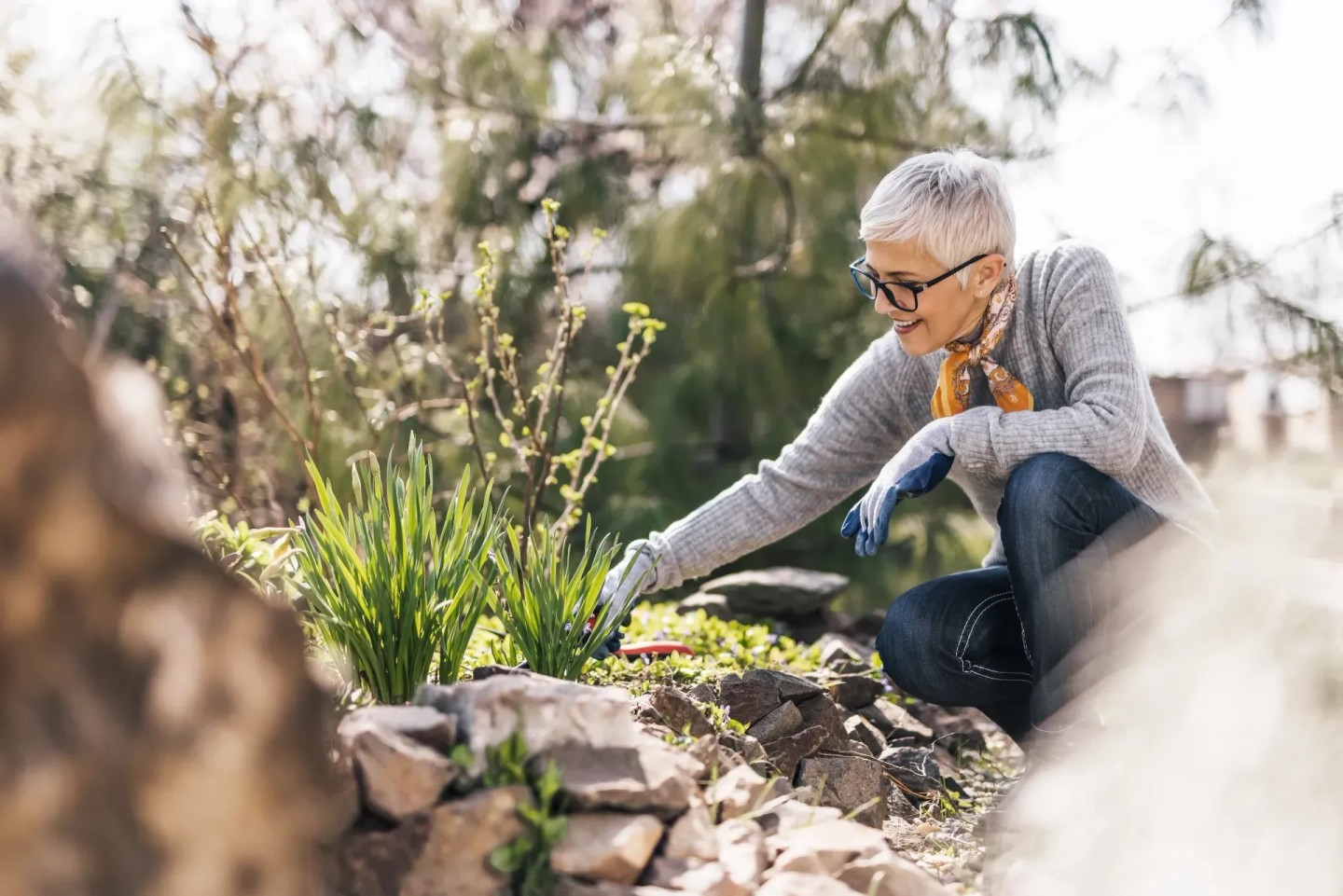 Eine Frau arbeitet im Garten. Sie pflegt ihren Garten im Frühling.