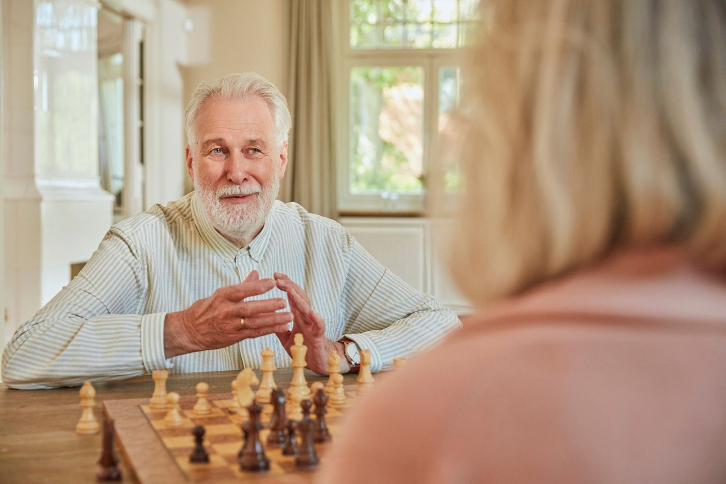 Ein älteres Ehepaar spielt Schach.