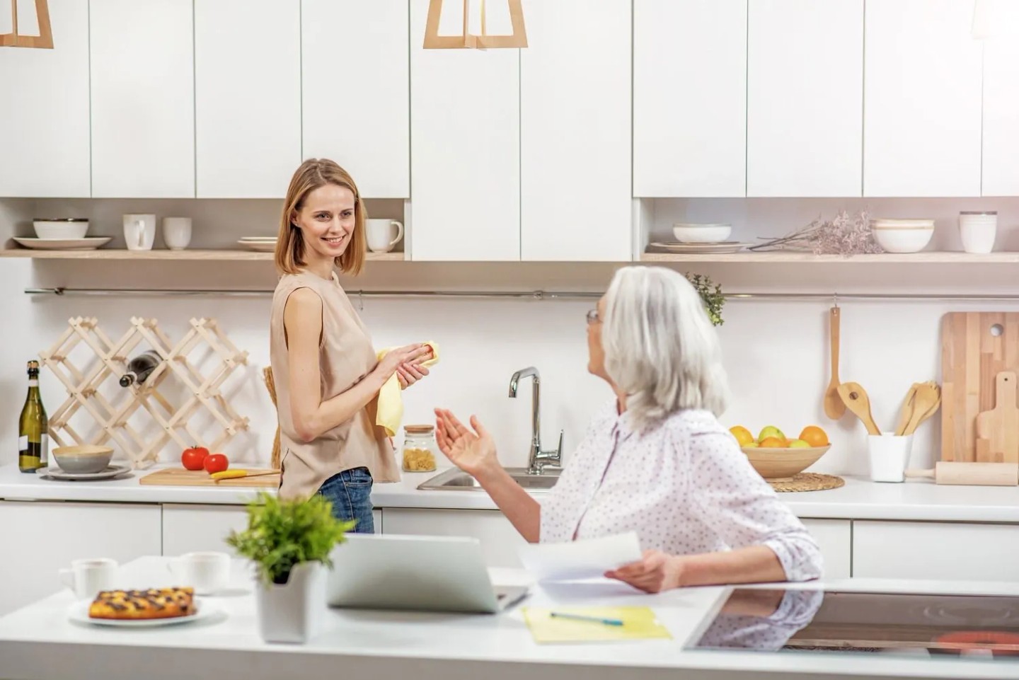 Eine Frau steht in der Küche und spricht mit ihrer Mutter.