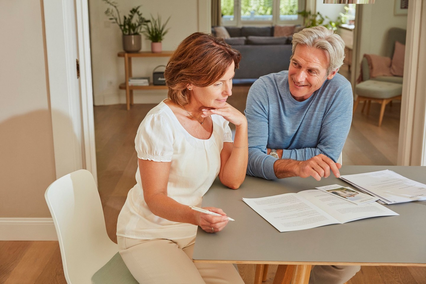 Zwei Kunden sitzen am Tisch und schauen sich Broschüren an.