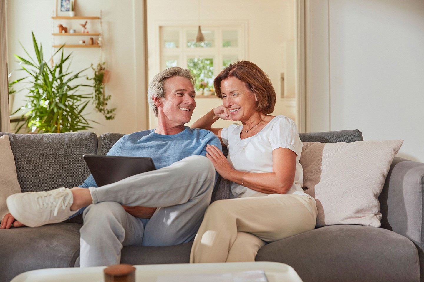 Paar sitz auf Sofa und schaut auf Tablet