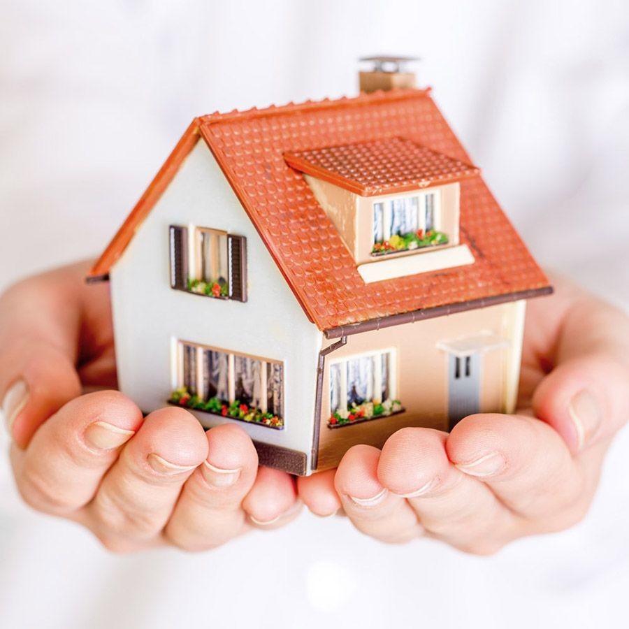 Ein Mann hält sein Haus in den Händen; Symbolbild für Immobilenverrentung