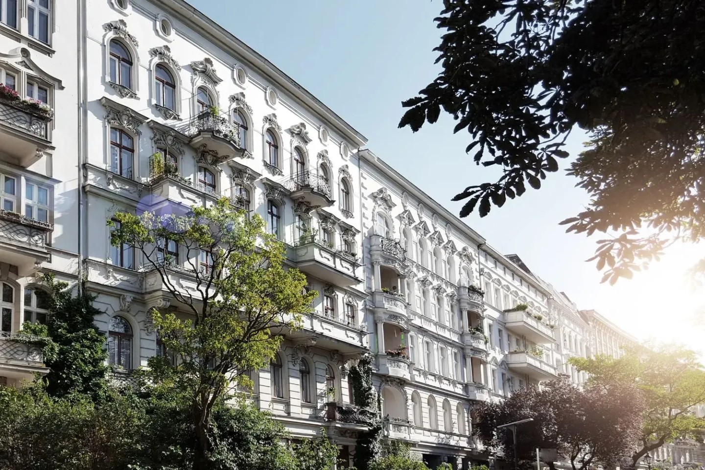 Ein Wohnblock von weißen Wohnungen und Bäumen.