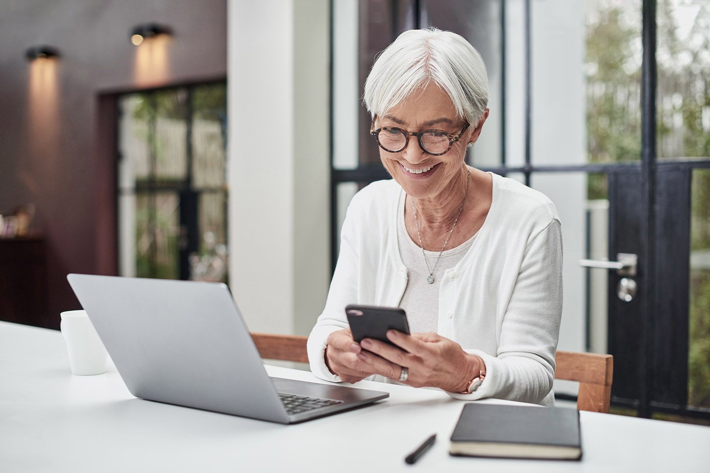 Glückliche ältere Dame am Schreibtisch