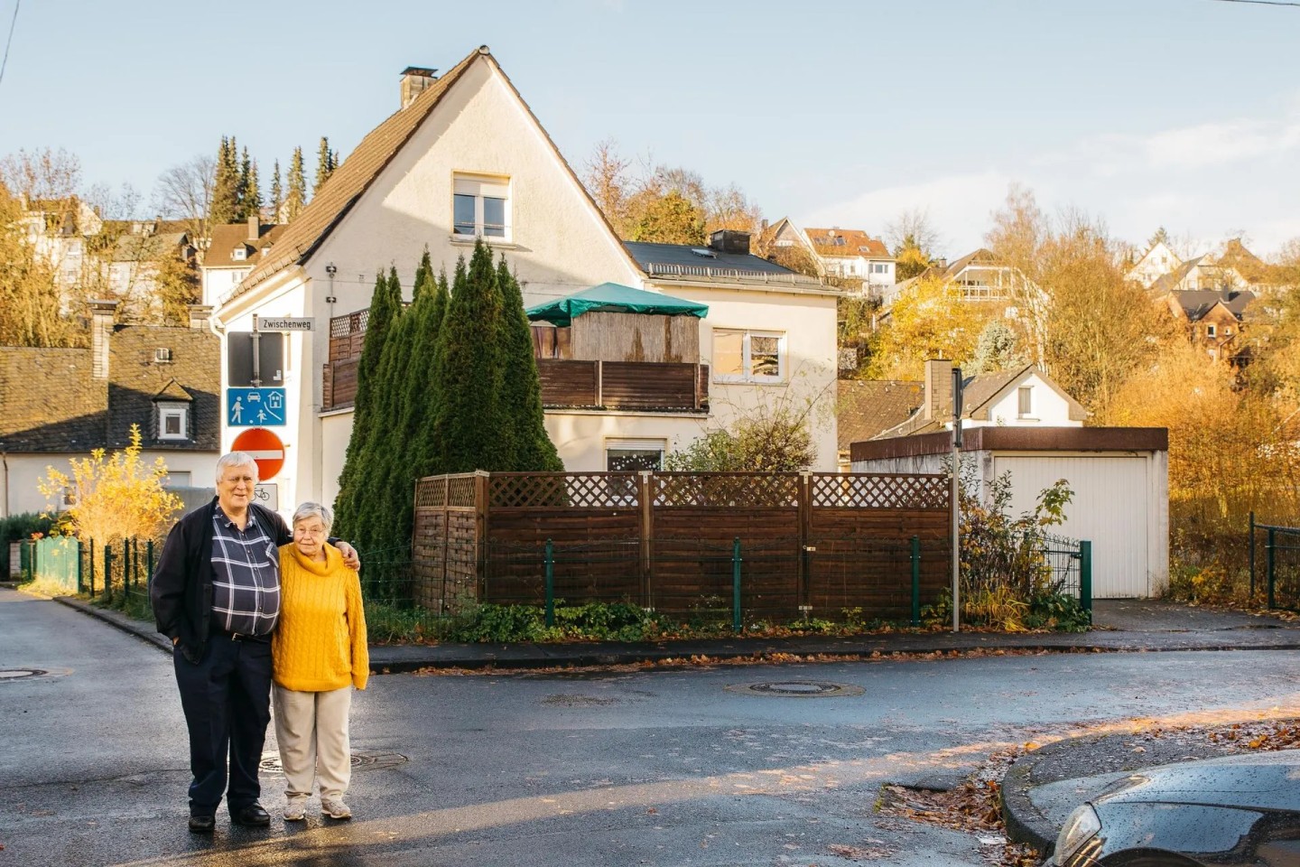 Ein Ehepaar steht auf der Straße vor Ihrer Immobilie. Sie freuen sich über den Teilverkauf.