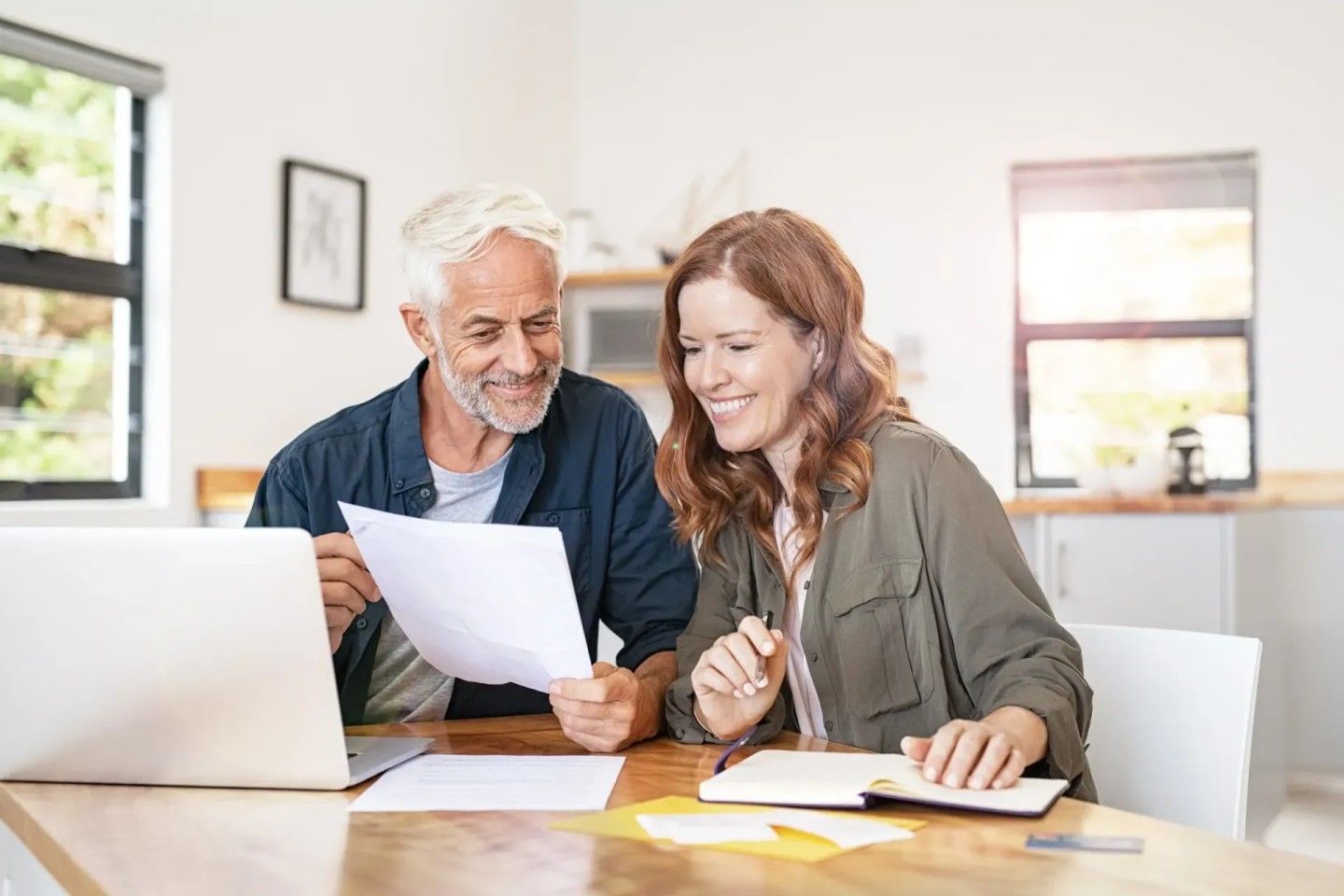 Ein Ehepaar sitzt am Tisch und schauen sich Unterlagen an. Sie machen sich Ängste um ihre Zukunft