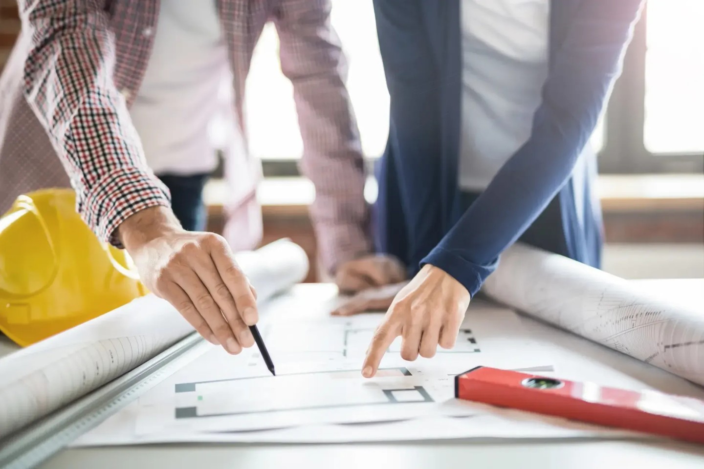 Zwei Personen halten Stift und Hand über einen Plan. Sie möchten die Immobilie seniorengerecht umbauen.